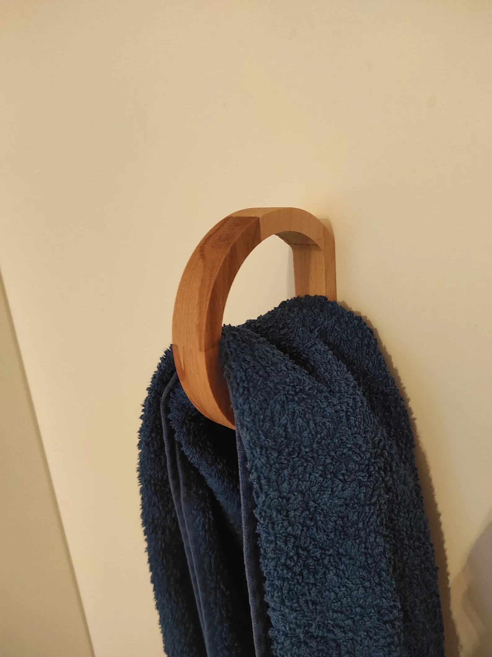 The wooden tone towel ring for wall use made from wood with adhesive support keeps towels accessible and organized