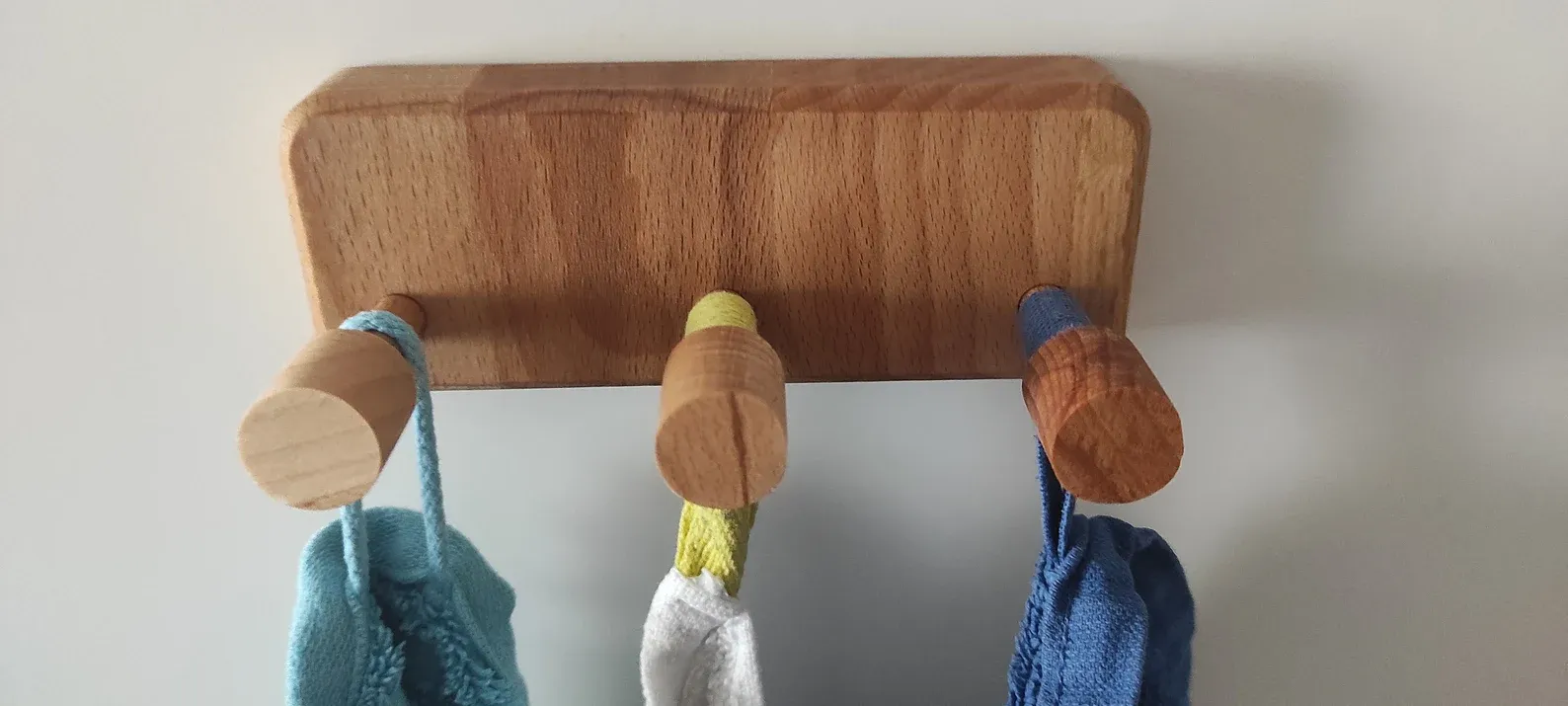 The wooden tone towel hooks for bathroom wall use made from wood with adhesive support help organize towels easily